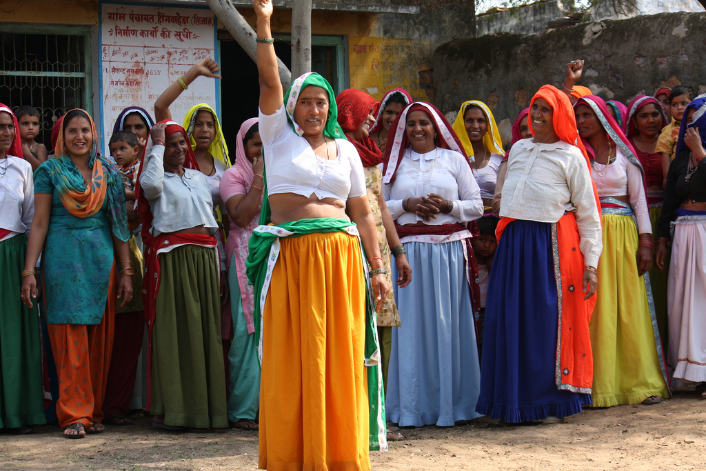 Group of women standing. The one in the foreground with fist raised.